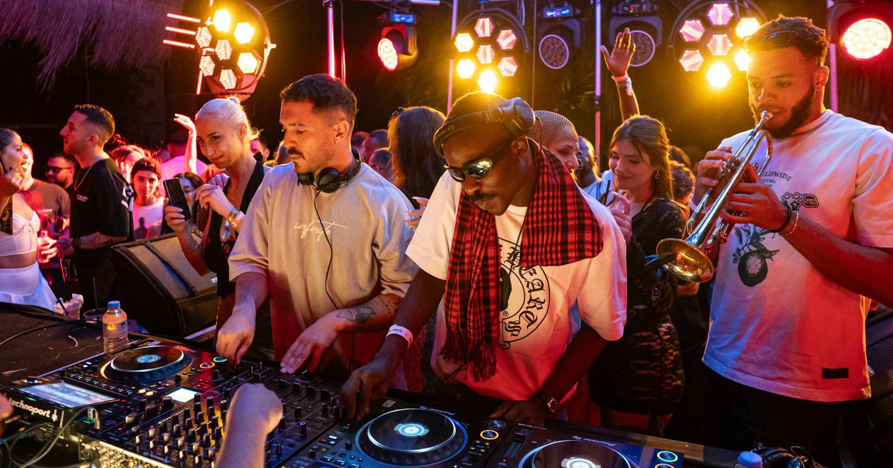 DJ and trumpeter performing for guests on a resort evening stage